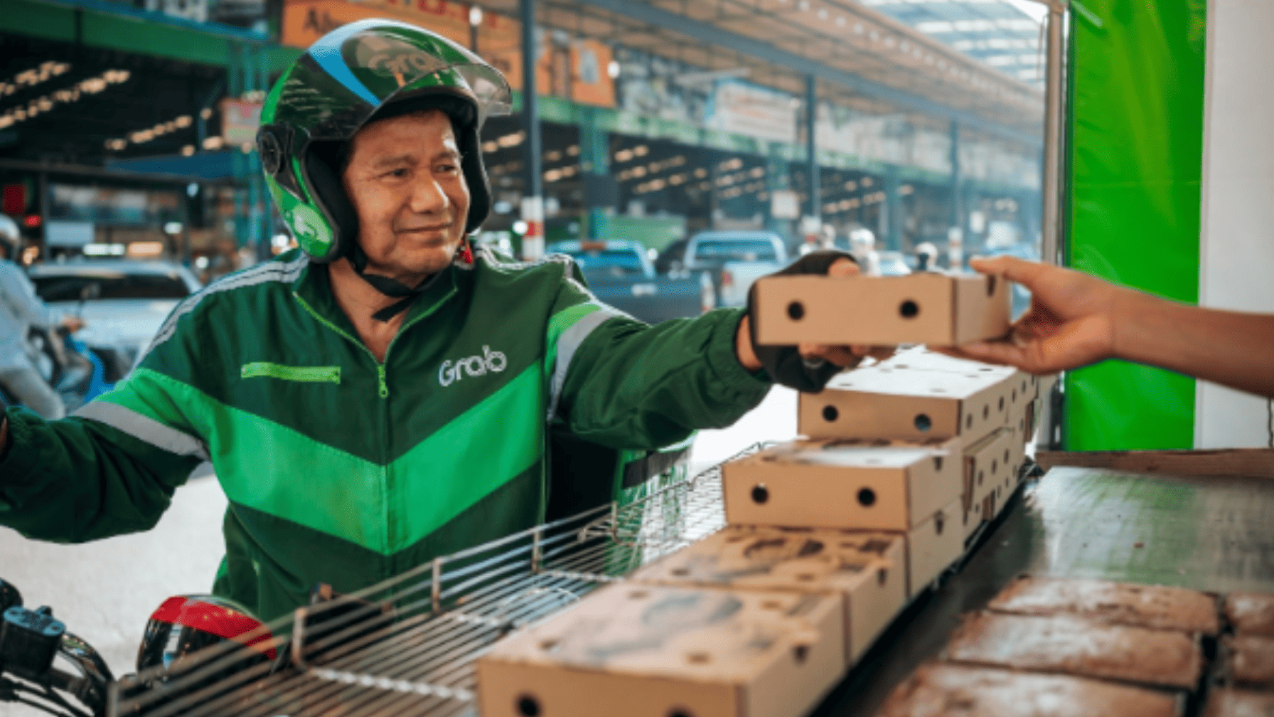 Delivery rider picks up multiple food packages at a market hub, showcasing efficient last-mile logistics in urban areas.